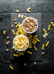 Pasta background. Dry conchiglle pasta and Farfalle in bowls.