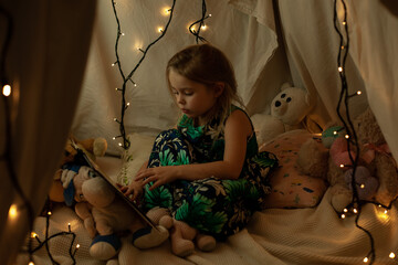 the girl is playing and reading a book in the hut