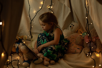 the girl is playing and reading a book in the hut