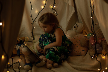 the girl is playing and reading a book in the hut