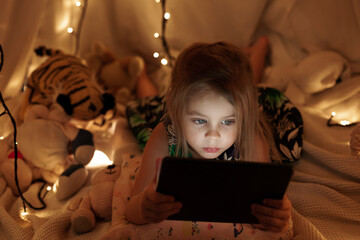 the girl is looking at the tablet