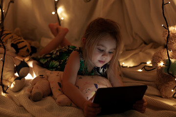 the girl is looking at the tablet