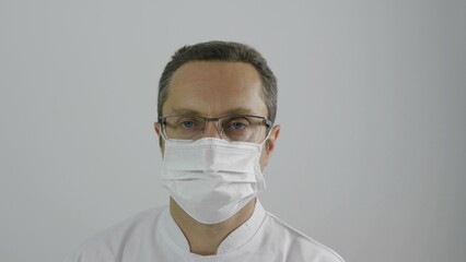 Portrait oh man doctor put on and take off protective mask to breath