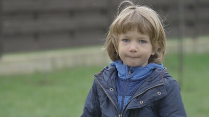 Portrait of little blond hair child play with yellow toy outdoor