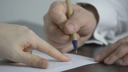 Hand holding pen sign final contract, woman hand explain and point with finger