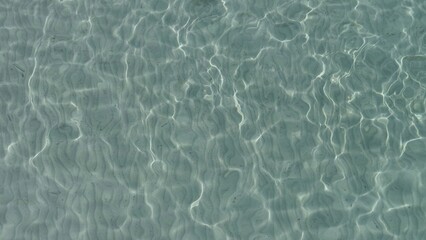 Detail of shallow clear sea water ripples on white fine sand
