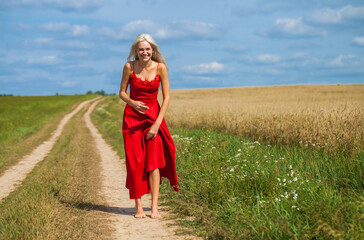 young woman in a red dress posing in a wheat field