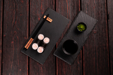 Maki shrimp sushi close-up. Shrimp fillet stuffing wrapped in rice and nori seaweed. Japanese cuisine top view