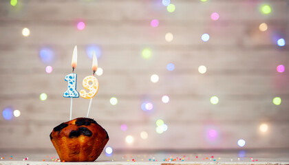 Happy birthday background with muffin and number of candles on light bulbs bokeh background....