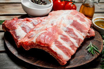 Raw ribs with spices and herbs .