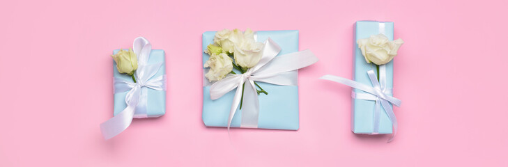 Different gift boxes with flowers on pink background, flat lay