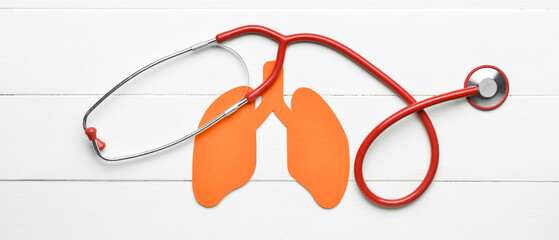 Paper lungs and stethoscope on white wooden background