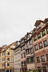Fototapeta na wymiar Old historic architecture in Nuremberg, Germany. Traditional European old town buildings with wooden windows, shutters and colourful pastel walls. Aesthetic summer vacation, tourism background