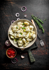 Dumplings with garlic, onion rings and tomato paste.