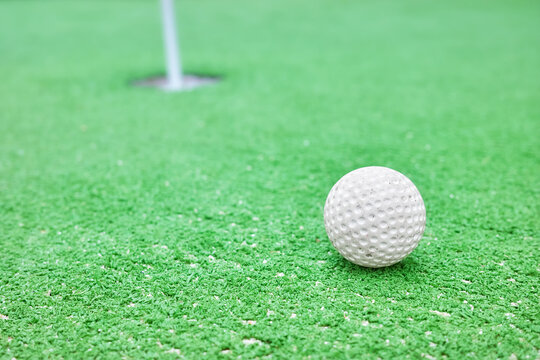 Close up picture of a golf ball at a mini golf course, selective focus.