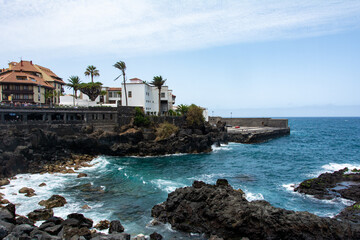 Fototapeta premium View of the coast and town of Puerto de la Cruz, Tenerife, Spain, with lava stones in the sea