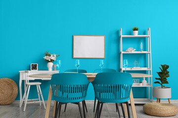 Interior of stylish dining room with big table, blue chairs and wall
