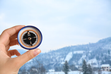 Naklejka premium Human hand with compass at winter resort