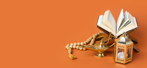 Aladdin lamp of wishes, prayer beads, Koran and Muslim lantern for Ramadan on orange background with space for text