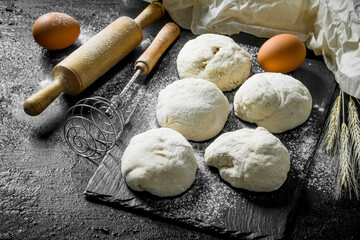 Fototapeta na wymiar Round pieces of dough with eggs and rolling pin.