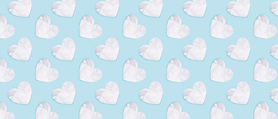 White crumpled paper hearts on blue background. Pattern for design