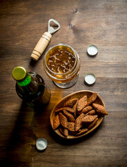 Beer in a glass and a bottle of crumbs in a bowl.