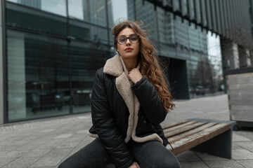 Fashionable beautiful young girl model with glasses in stylish winter clothes with a knitted...