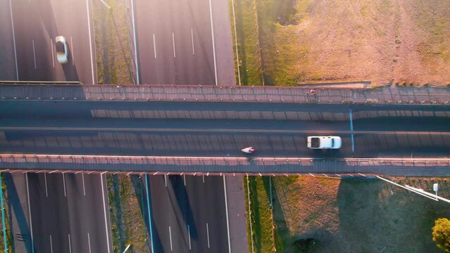 overhead view of bridge and highway with vehicles at sunset,