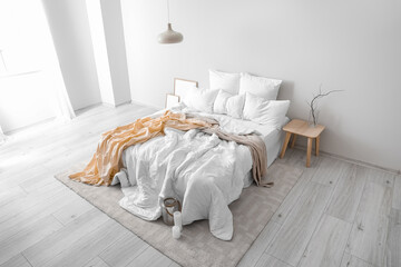 Interior of light room with big bed and table