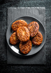 Cutlets in a plate on a stone Board.