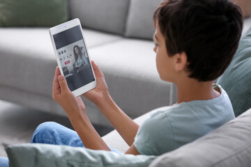 Little boy video chatting with psychologist at home, closeup