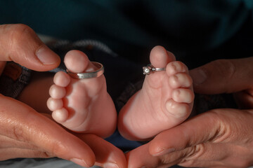 Les pieds d'un nouveau-né dans les main de son père