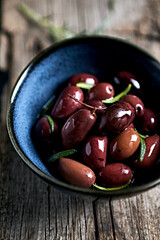 Kalamata olives with rosemary in olive oil. Close-up
