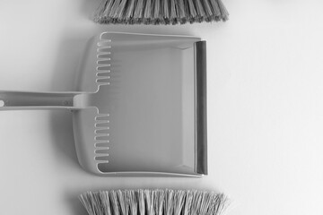 Dustpan and cleaning brushes on light background