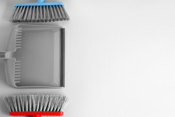 Dustpan and cleaning brushes on light background