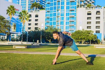 Young muscular man exercising outdoor, city park, downtown, summer. healthy lifestyle concept.
