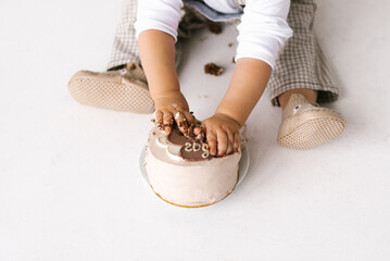 Trendy Korean dessert bento cake beige color will be crushed in the hands of a small child. Dessert...
