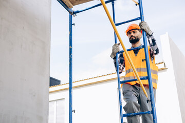 Foreman climbing ladder at building object © Petro