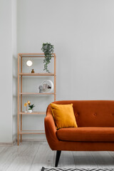 Interior of living room with brown sofa and shelving unit near grey wall