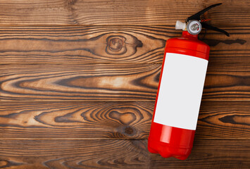 Fire extinguisher on brown wood background. Fire protection, home fire extinguisher. home security...