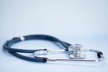 medical stethoscope and a blue background and copy space for insurance planning, protection and safety concept of balance and reliability of medical health insurance.