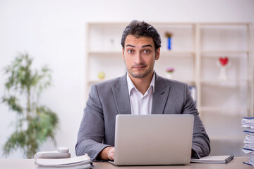 Young male employee and too much work in the office