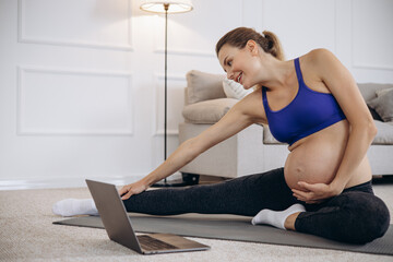 Fototapeta na wymiar Pregnant woman practicing yoga at home