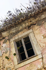 Bottom view of an empty dark window of an old abandoned house