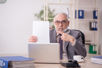 Old male employee working in the office