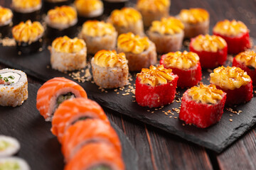 Sushi set from top on black background close-up. An assortment of various maki nigiri and rolls seafood soy sauce