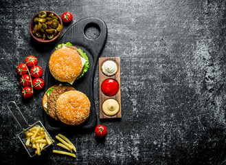 Burgers with fries,tomatoes and jalapenos in bowl .