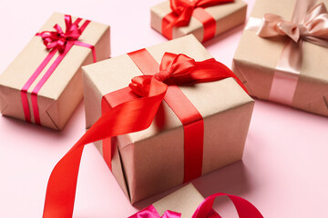 Gift boxes with bows for Valentine's Day on pink background, closeup