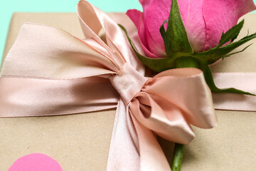 Gift box with beautiful bow and rose flower, closeup. Valentine's Day celebration
