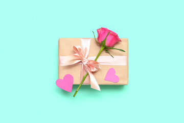 Beautiful gift with rose flower for Valentine's Day celebration on color background
